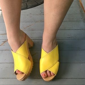 Yellow leather and wood cross-strap clogs